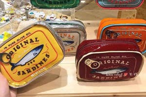 zippered makeup bags that look like sardine tins in various colors 