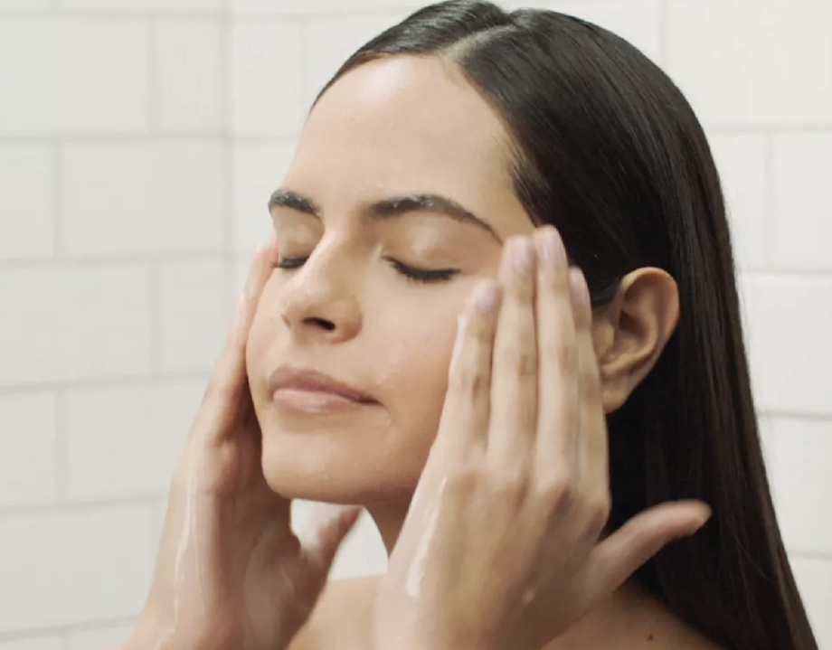 Model using the CeraVe hydrating facial cleanser on their face