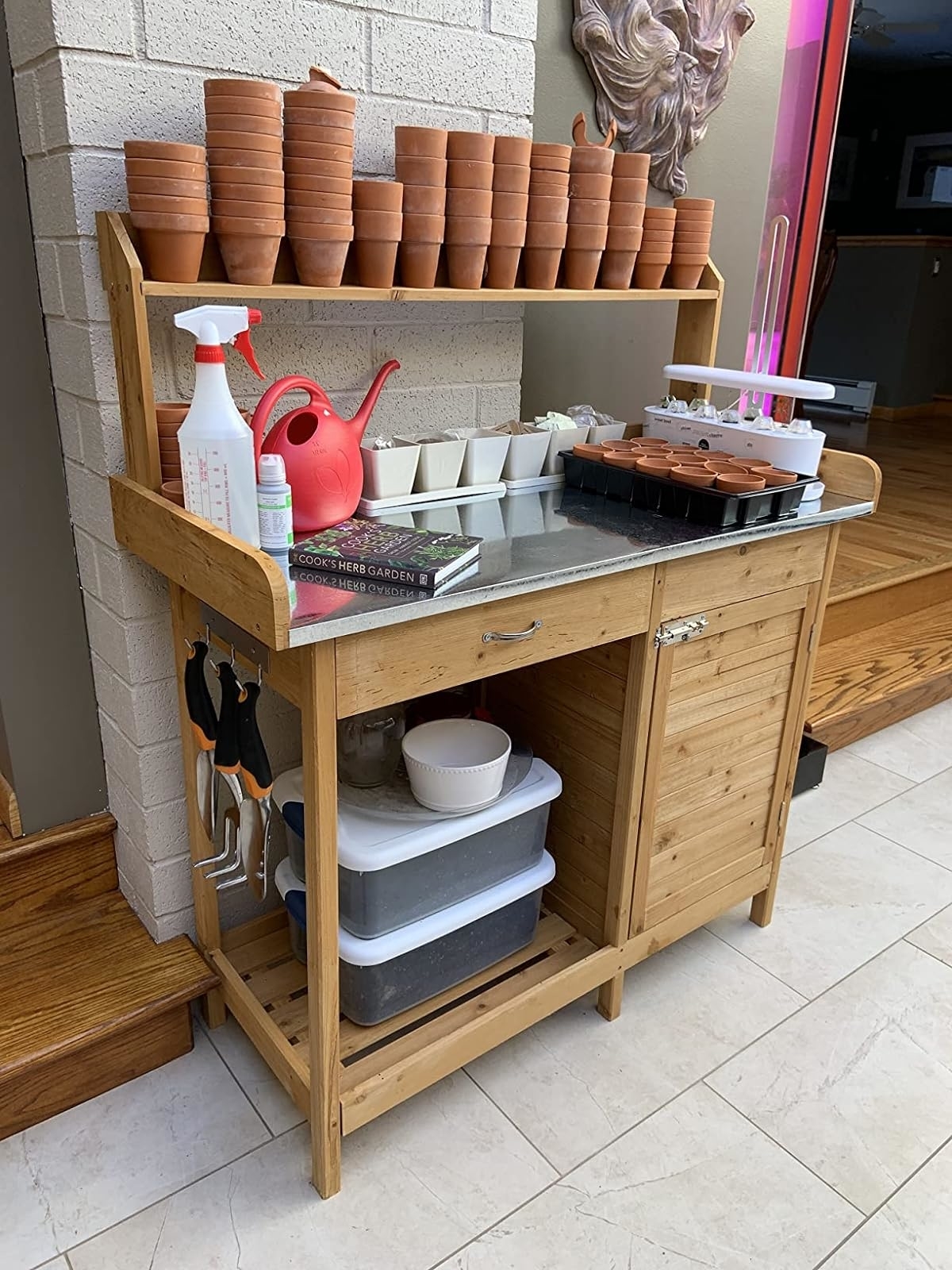 Wooden gardening station with shelves, supplies, and pots, showcasing storage solutions for garden tools and accessories