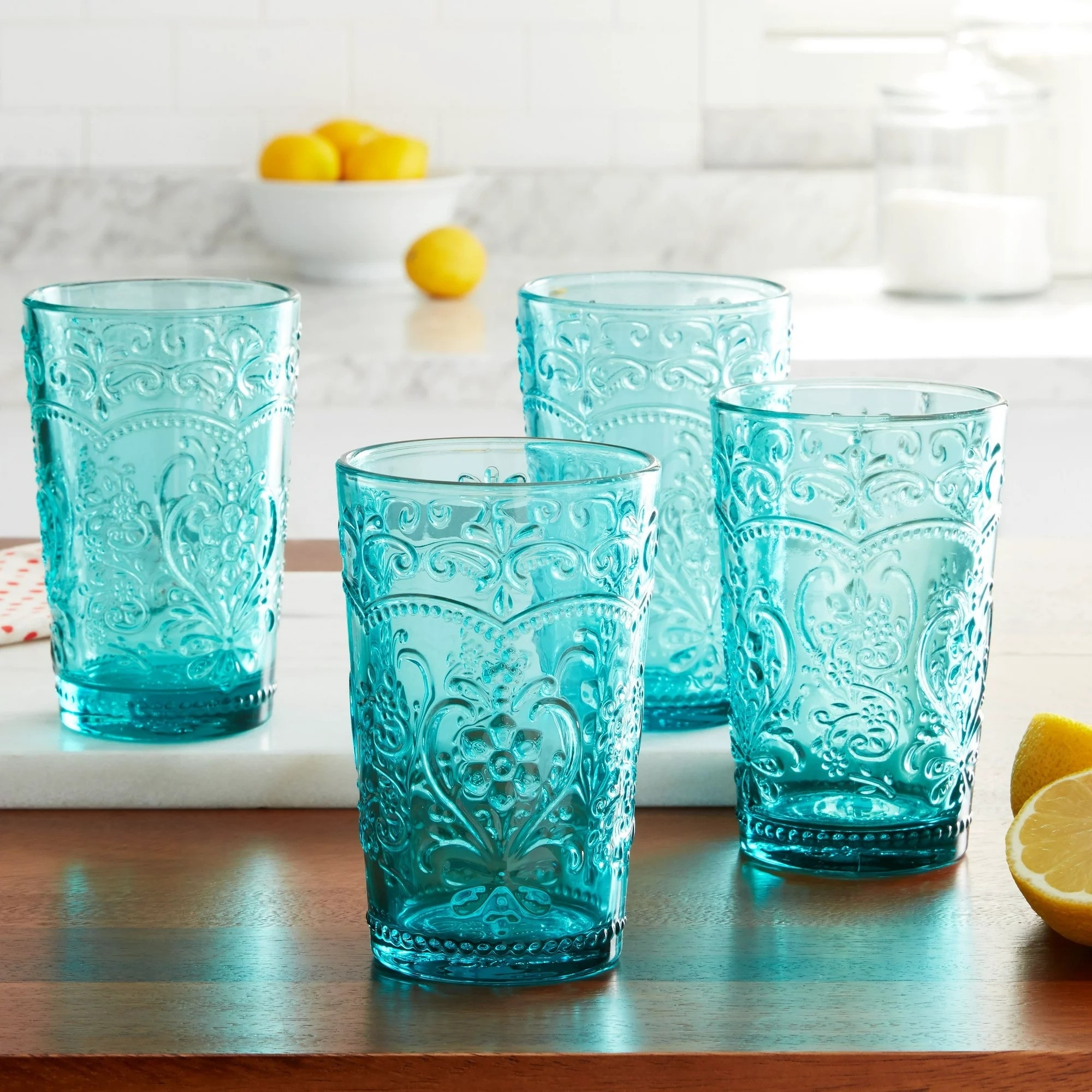 Four embossed drinking glasses on a kitchen counter in blue