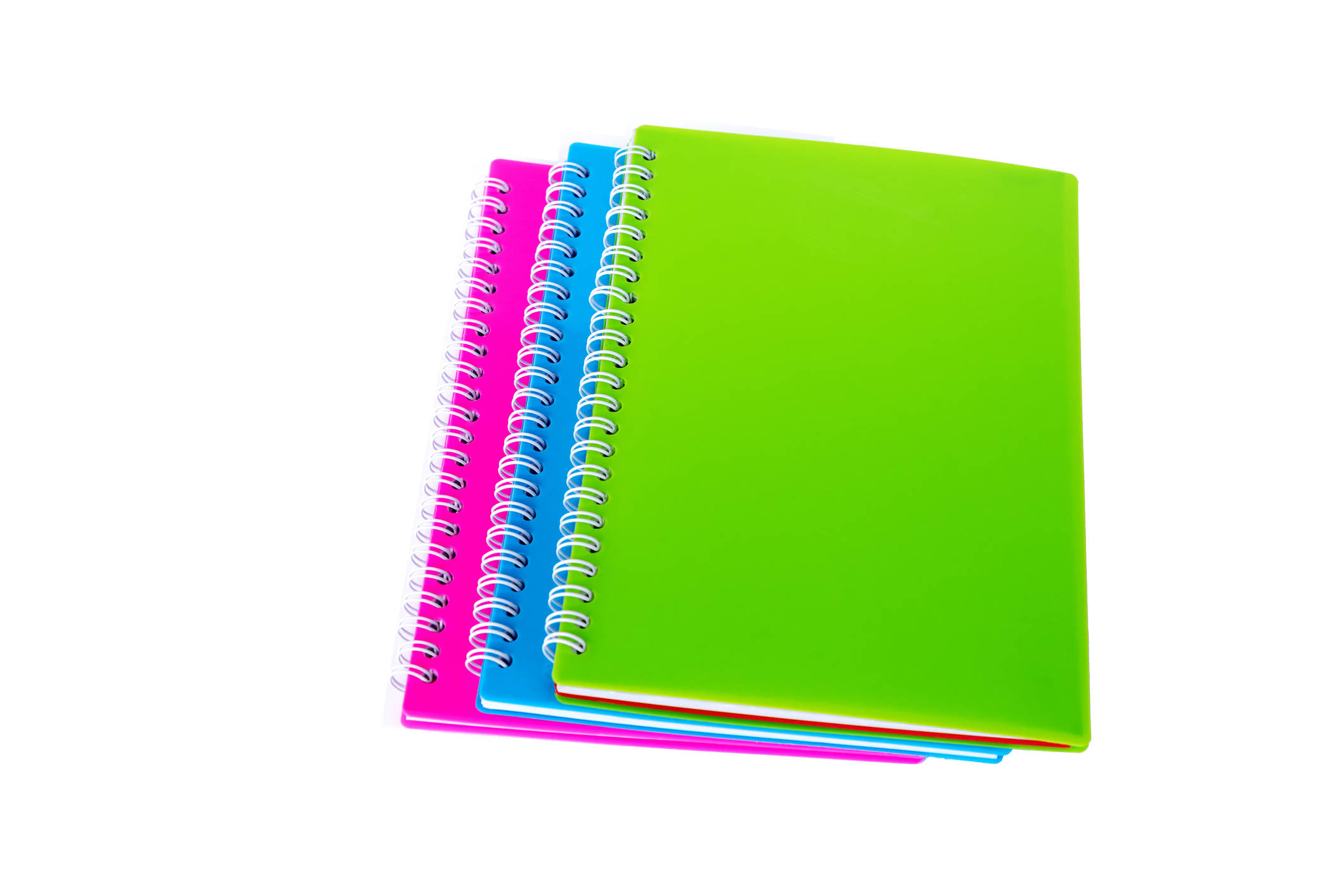 Stack of three spiral notebooks on a plain background