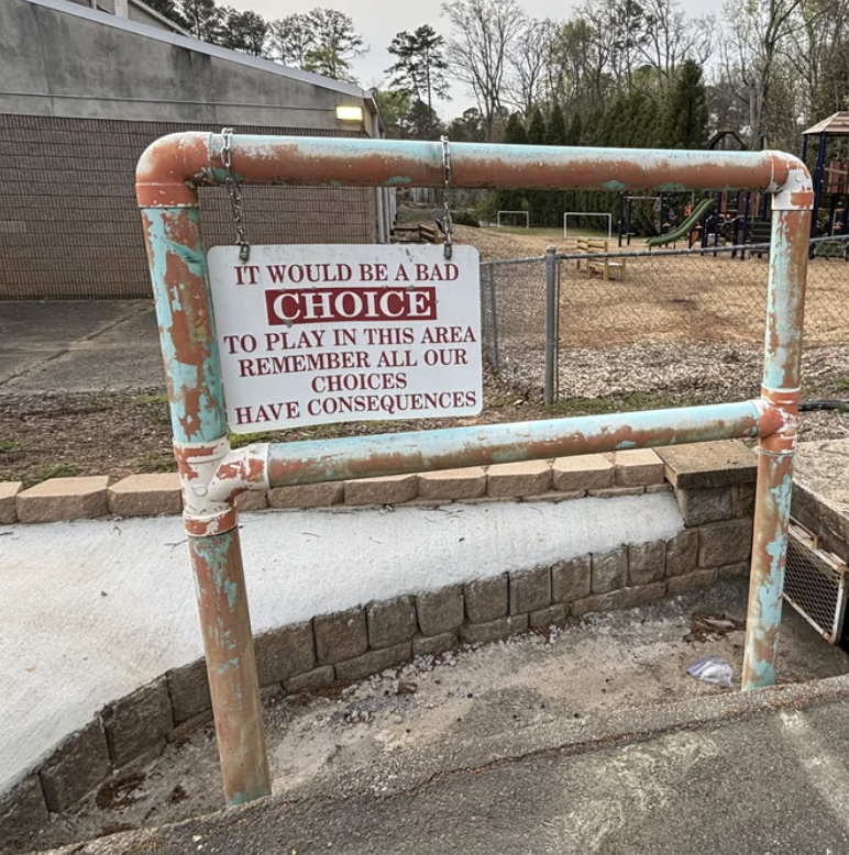 Warning sign on a dilapidated playground structure cautioning against play due to unsafe conditions