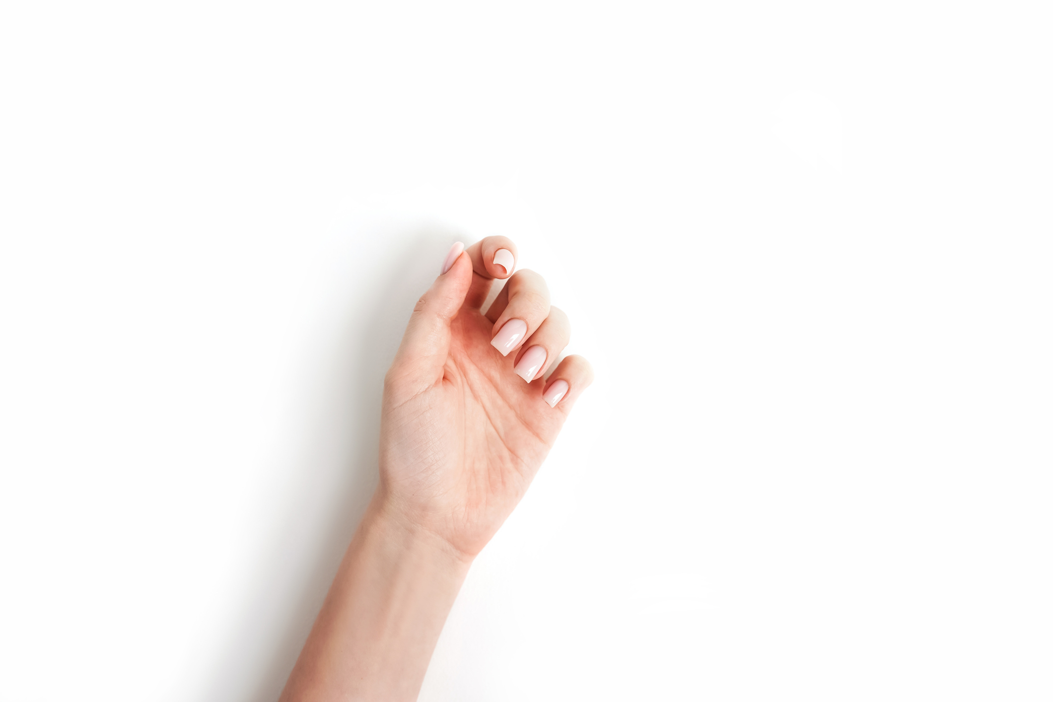 Person&#x27;s hand making a &#x27;pinkie promise&#x27; gesture on a plain background