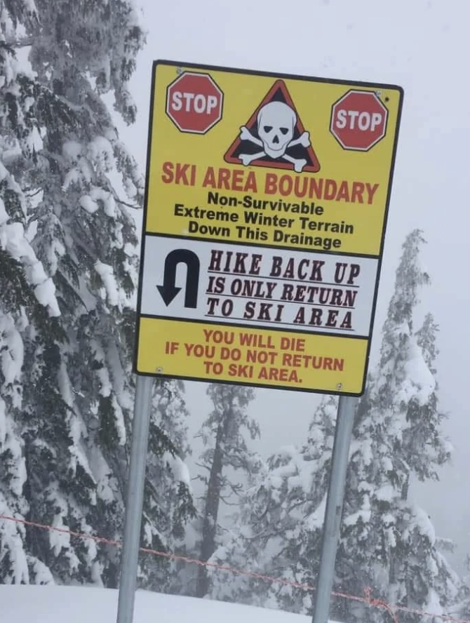 Warning signs on ski slope indicating danger beyond boundary and necessity to return to ski area to avoid death
