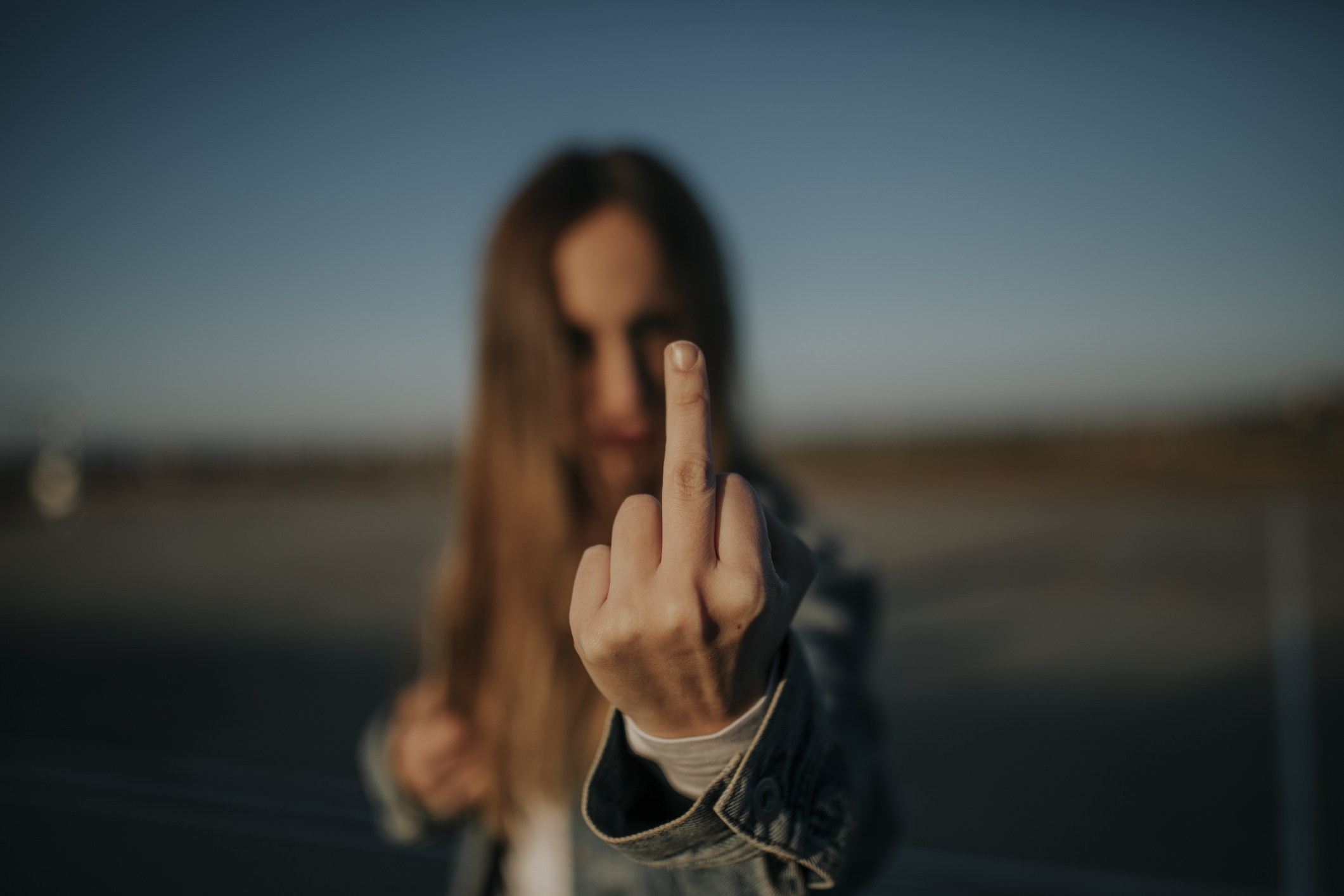 Person extending middle finger towards the camera in a dismissive gesture