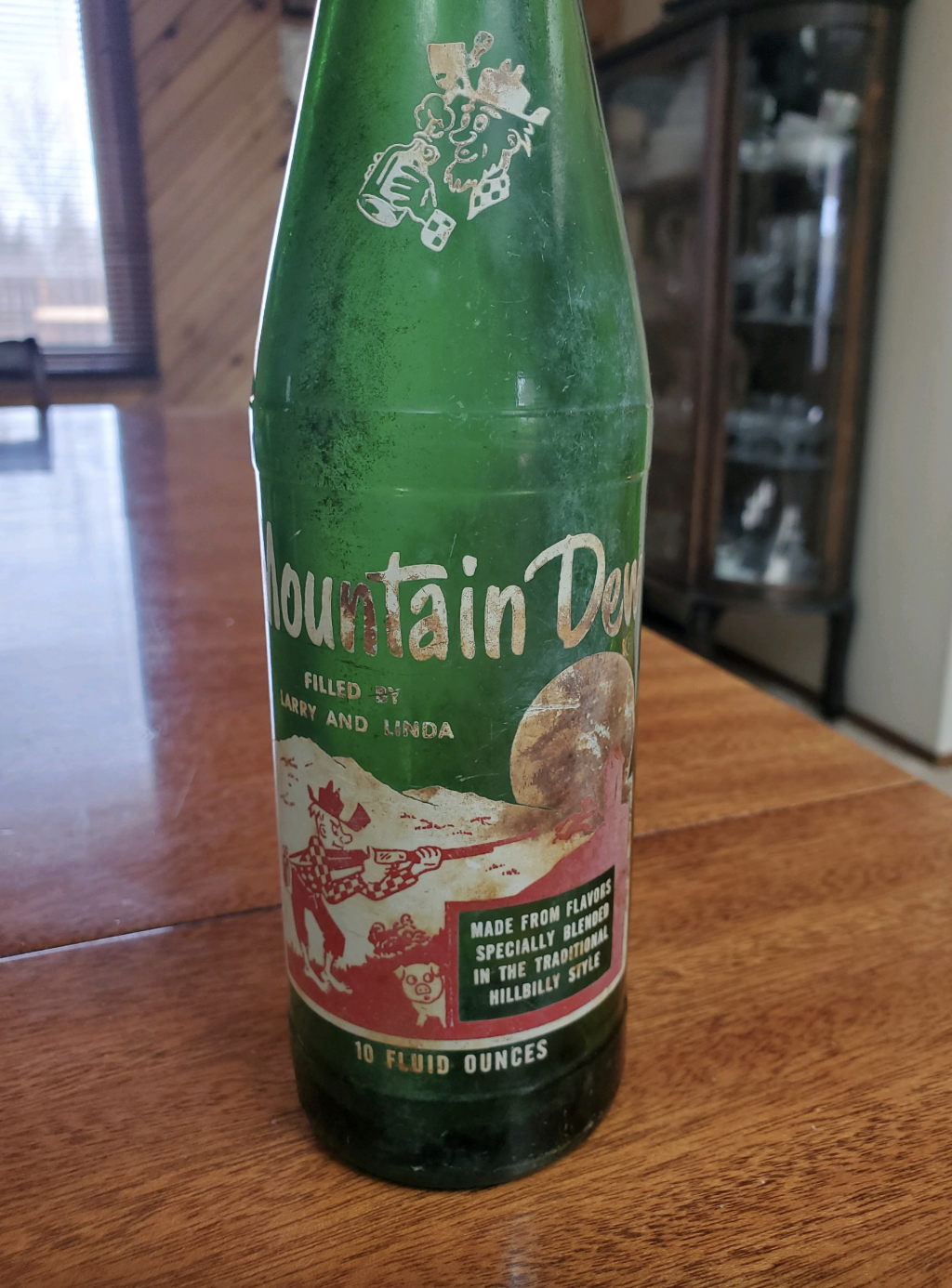 Vintage Mountain Dew bottle with old logo and illustrations, text about the brand origins