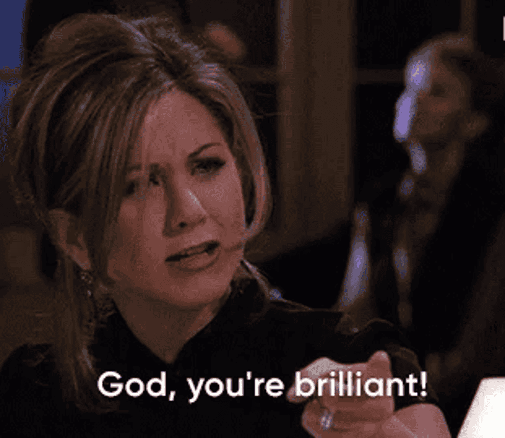 gif of Rachel from Friends in a dark top expresses admiration with a hand gesture that reads god. you&#x27;re brilliant