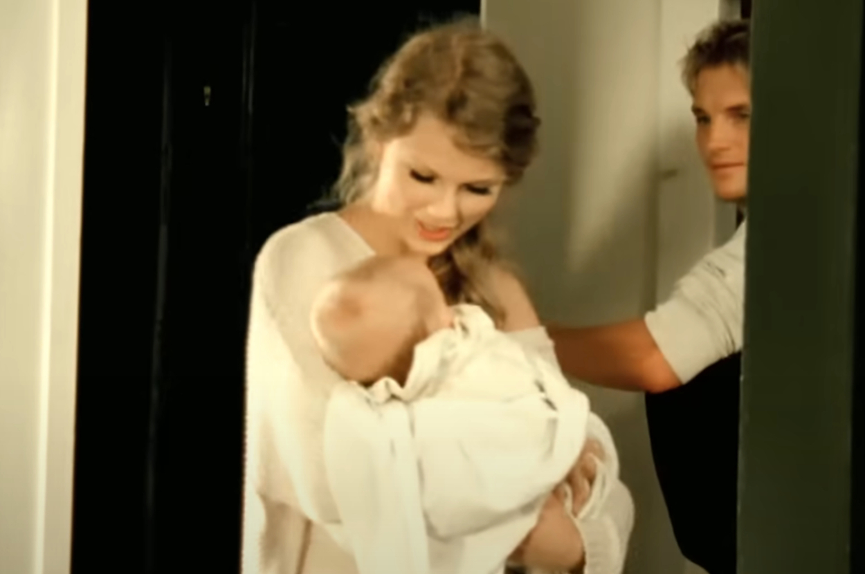 Taylor Swift holding a baby in the Mine music video