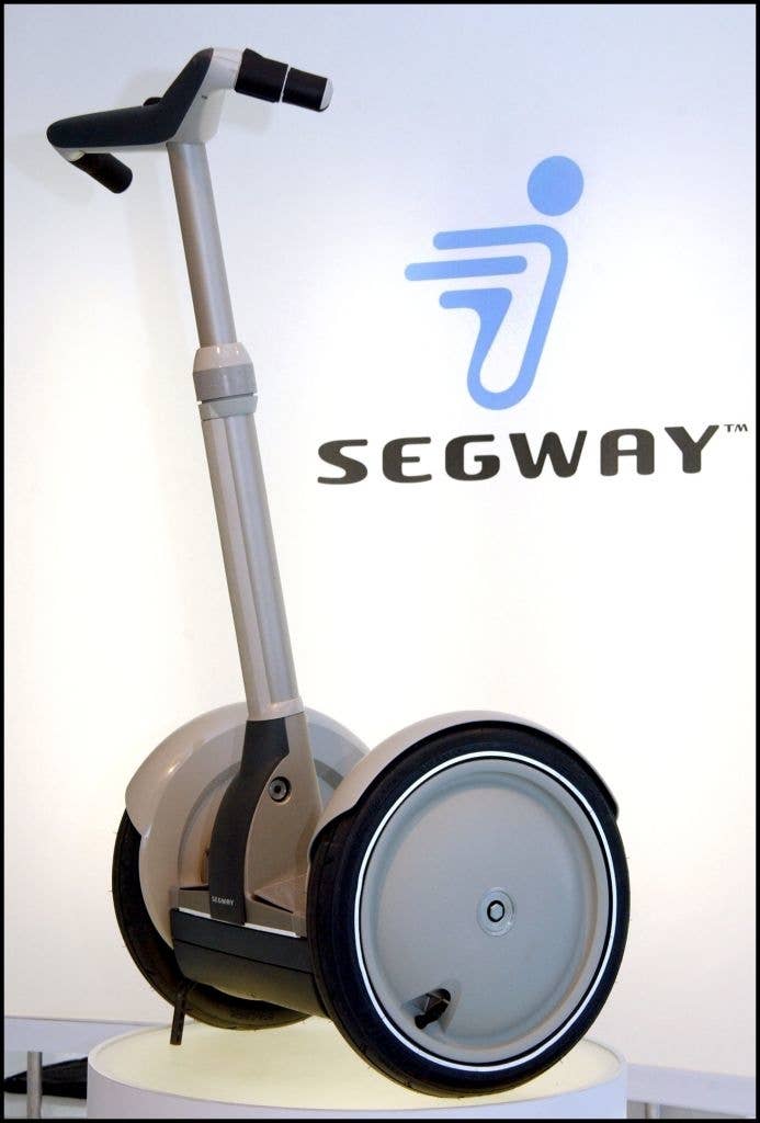 Segway personal transporter displayed with logo in the background