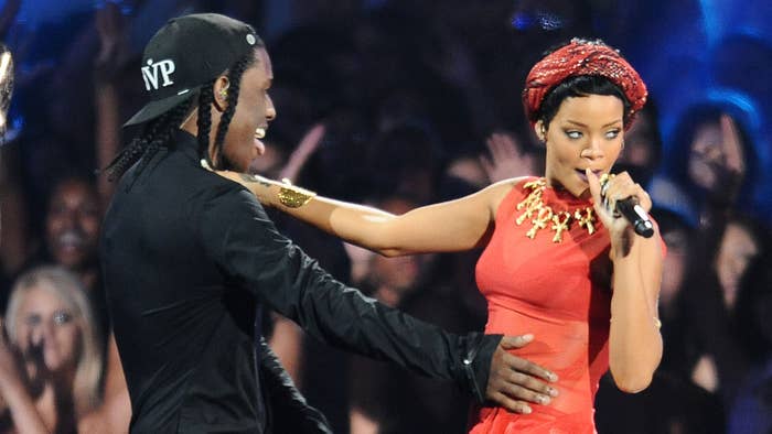 Two performers on stage; Rihanna in red with a headset mic, ASAP Rocky in black with cap, engaging with the audience