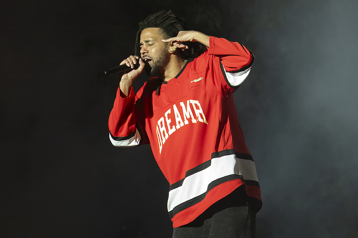 Musician in a 'Dreamer' jersey performs on stage with a microphone