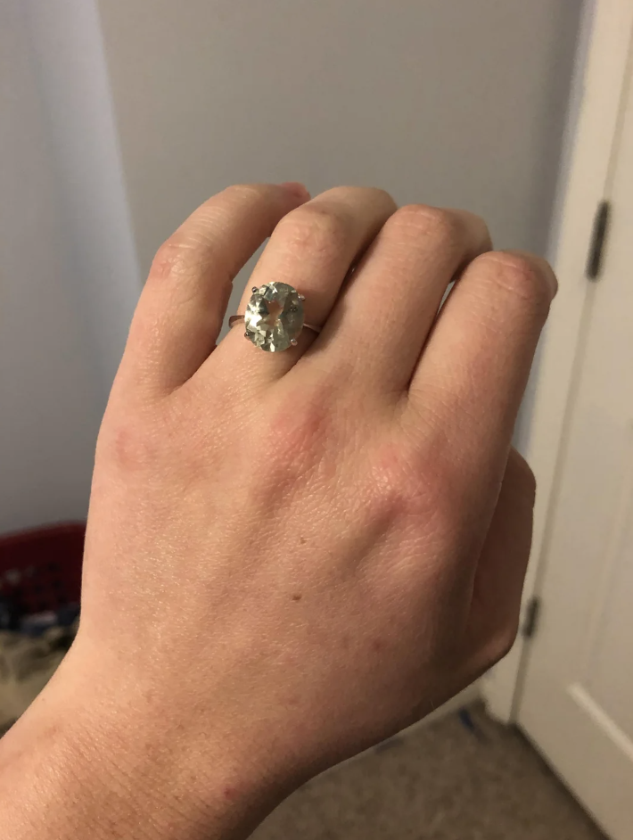Hand wearing a large gemstone ring