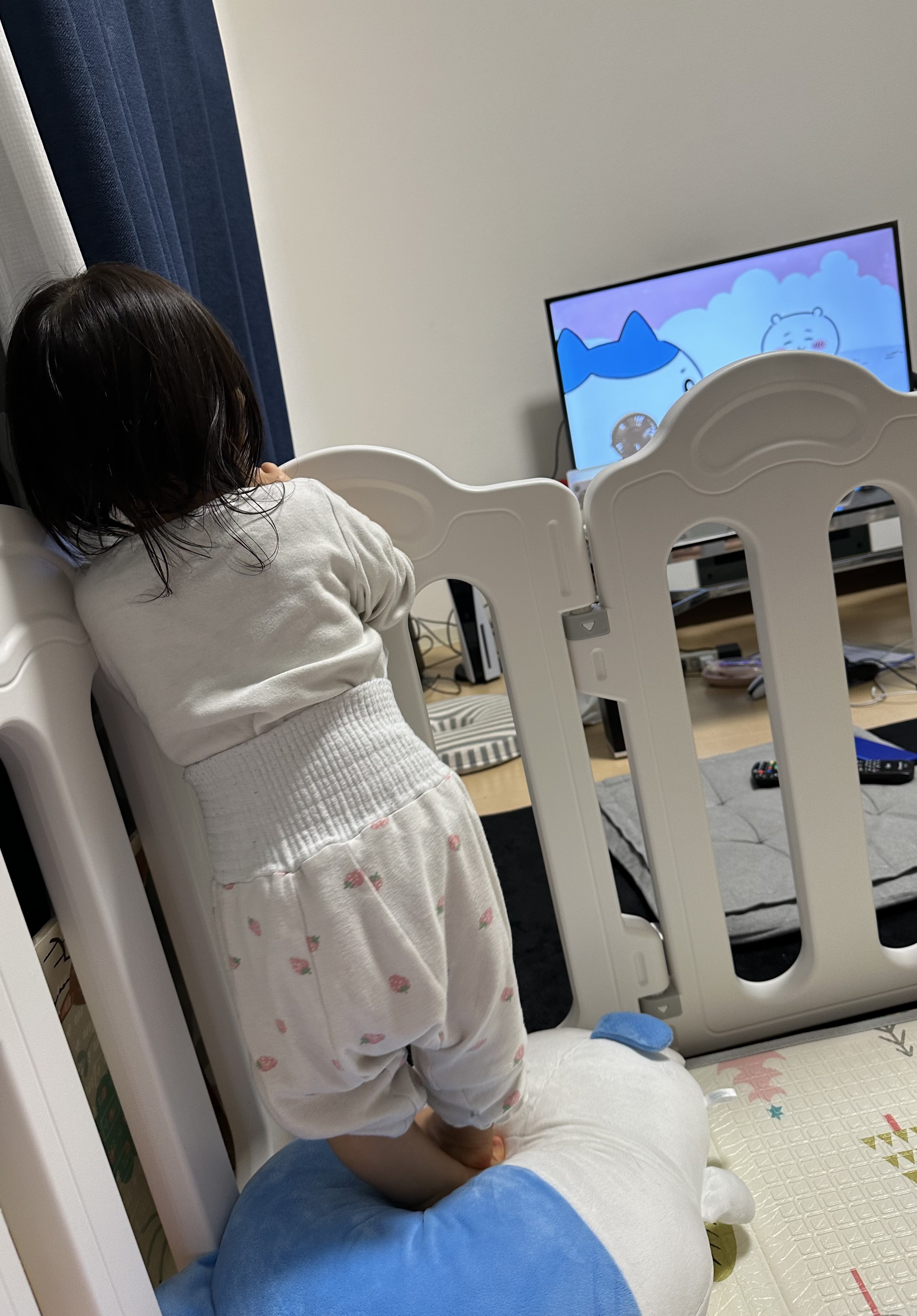 テレビでアニメを観る幼児、背中向けて立っている。