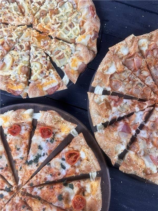 ピザ３枚が並んでおり、異なるトッピングが施されている。