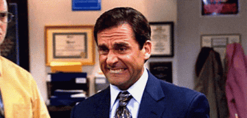 Michael Scott from The Office grimacing in discomfort during a conversation