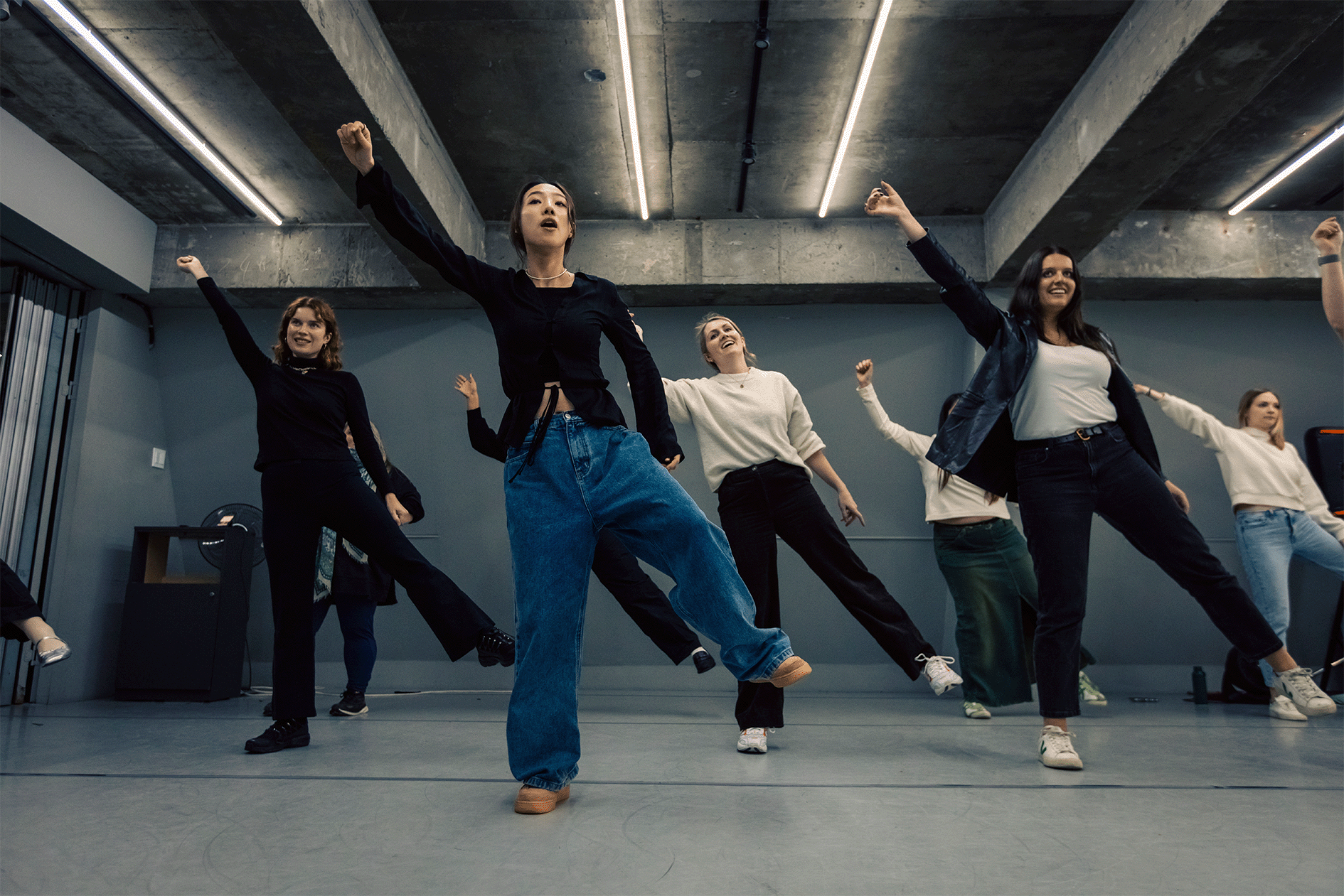 Group of people practicing a dance routine in a studio setting