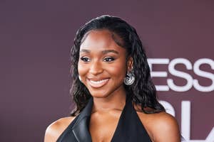 Normani poses in a sleeveless black jumpsuit with a plunging neckline and a vest-style top