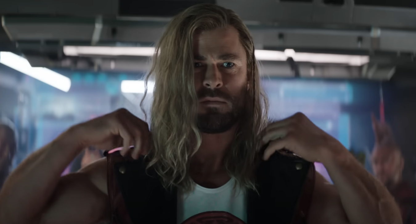 Chris Hemsworth as Thor in a tank top, flexing, with a focused expression