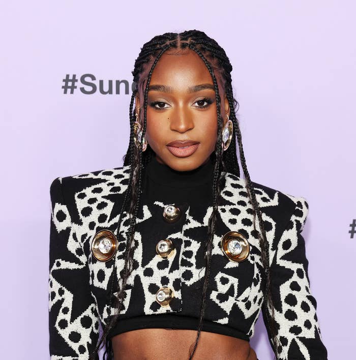 Woman in a black and white patterned jacket with braids, posing at Sundance event