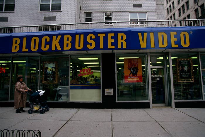 Exterior of a Blockbuster Video store with signage, idiosyncratic with stroller lasting nearby