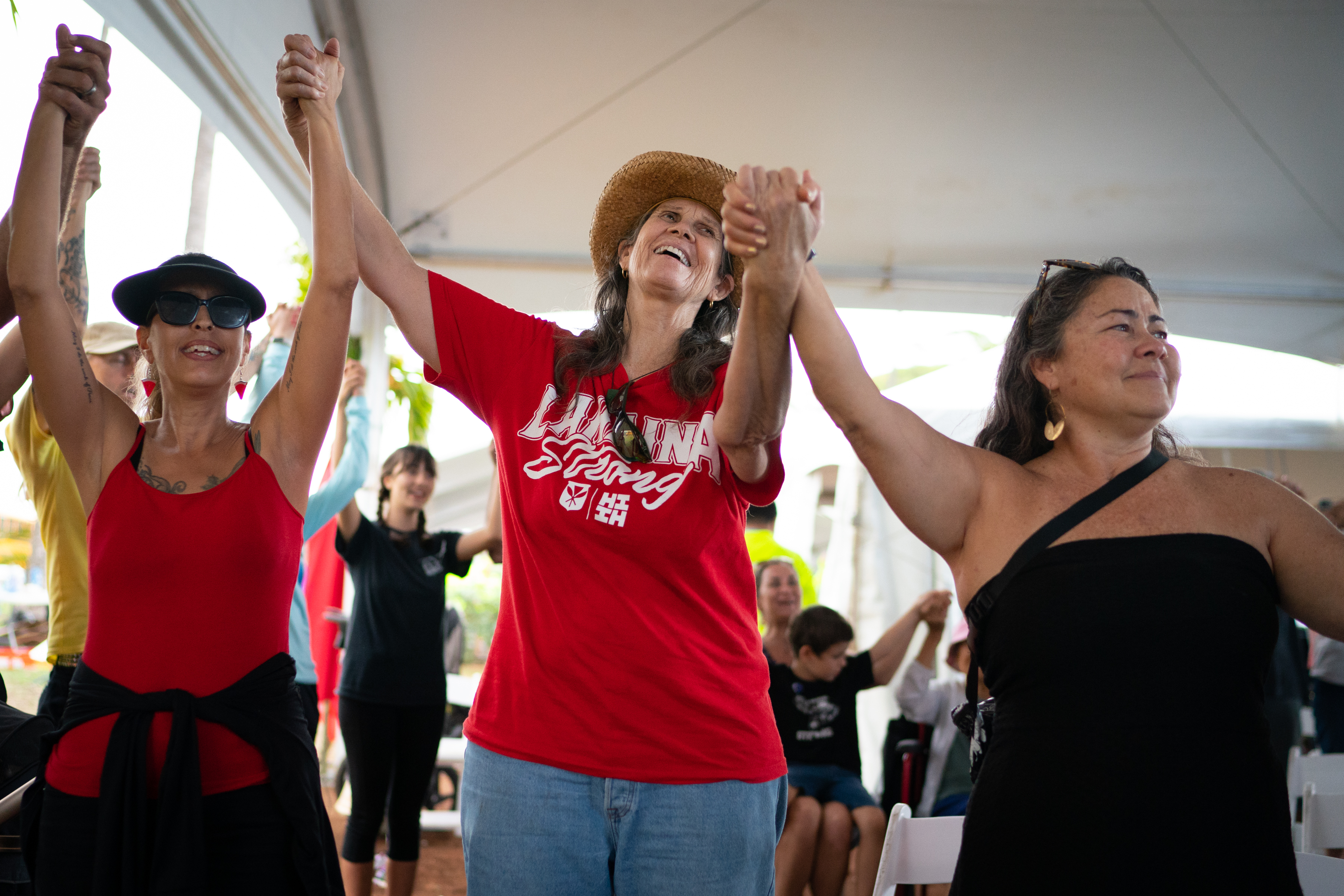 Three women holding hands raised in celebration