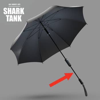Black umbrella featured on Shark Tank, shown floating against a gray background with an arrow pointing to the extended handle 