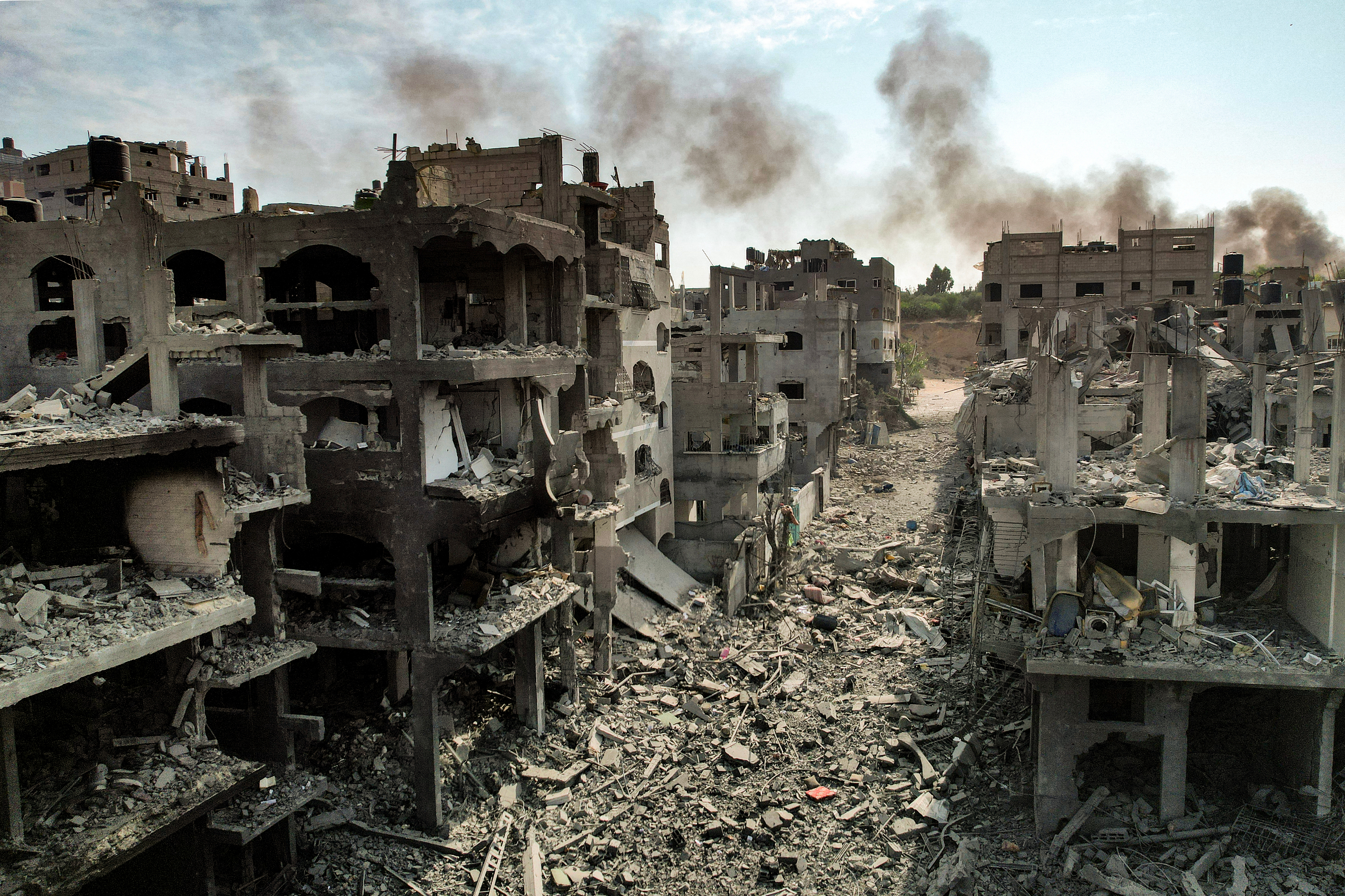 Destroyed buildings in a devastated area, rubble scattered on the ground
