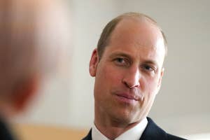 Prince William in conversation, wearing a dark suit and tie