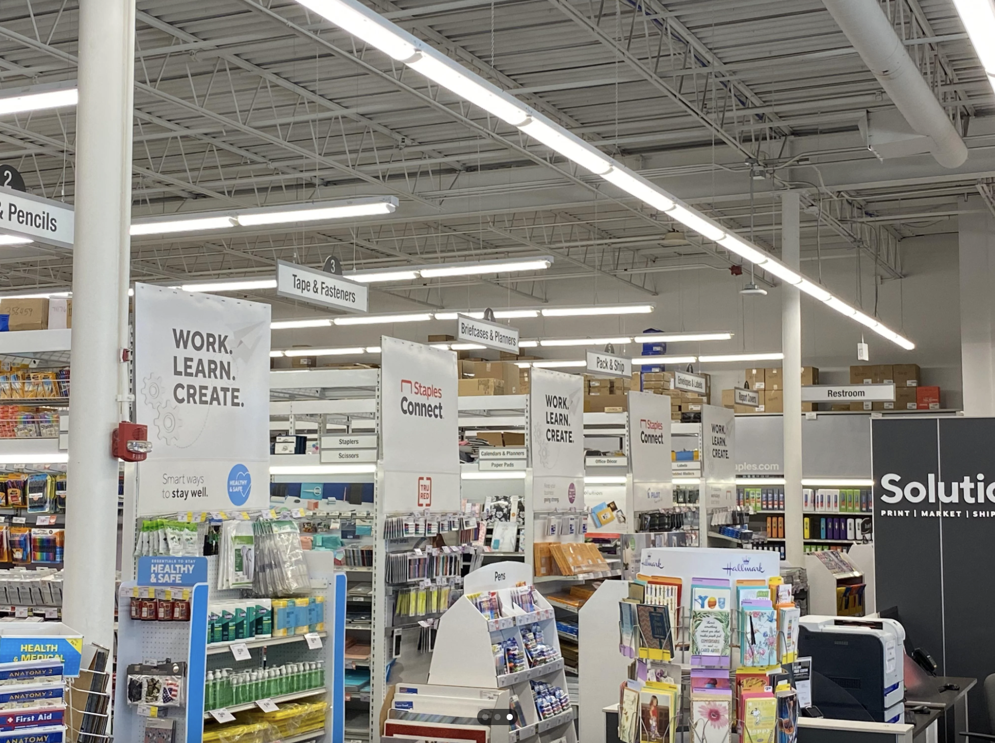 Interior of a Staples store with promotional signs for work and learning products