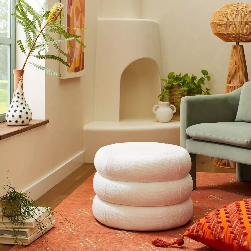Two-tiered white ottoman in a cozy living room setup with contemporary furnishings