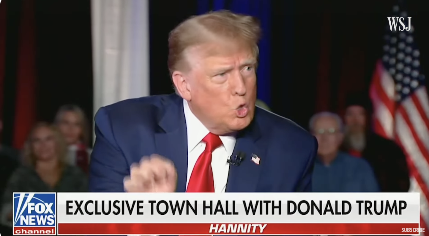 Former President Donald Trump speaking at an exclusive town hall event with host Hannity, with American flags in the background