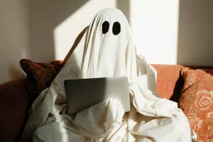 a person dressed as a ghost using a laptop