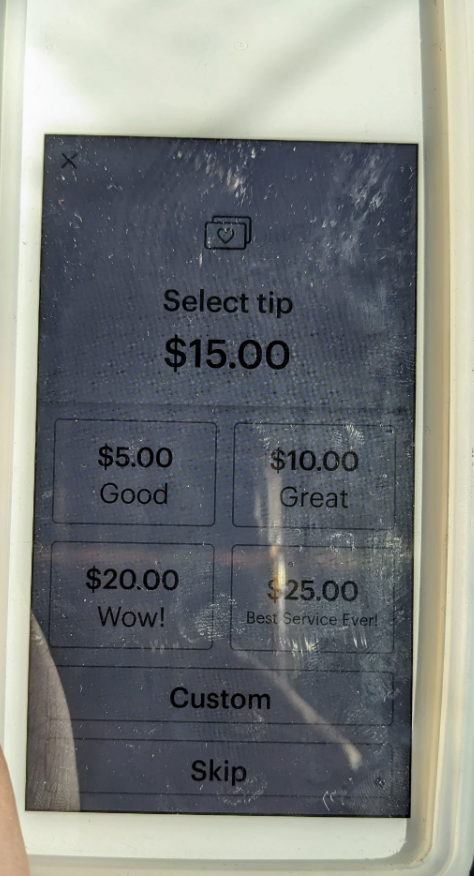 Digital payment device displaying tip options: $5, $10, $15, $20, and custom, with $15 selected