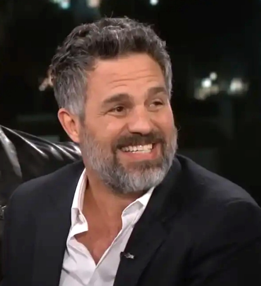 Mark in suit smiling during an interview