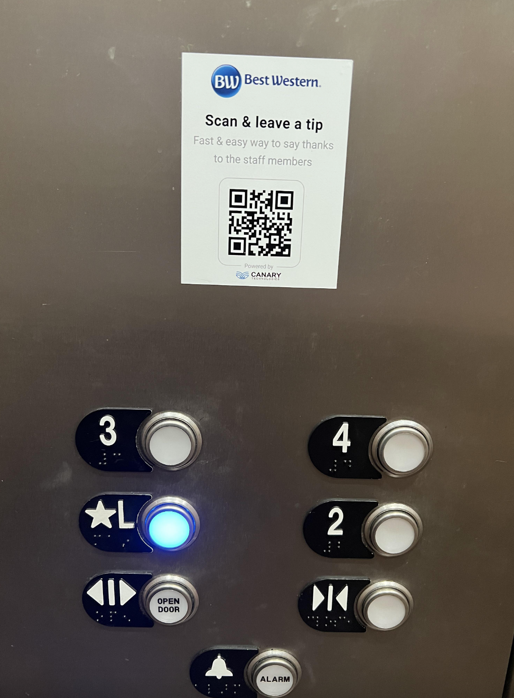 Elevator panel with floor buttons, a QR code for tipping, and braille numbers beside each button