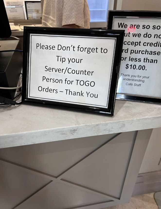 Sign at a counter reminding to tip server or to-go person with a minimum $10.00 credit card charge notice