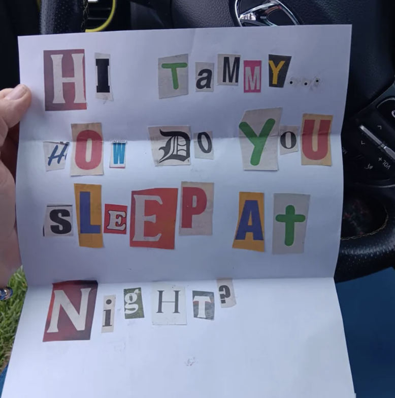 Paper with cutout letters glued on, spelling &quot;Hi Tammy... How do you sleep at night?&quot; held inside a car