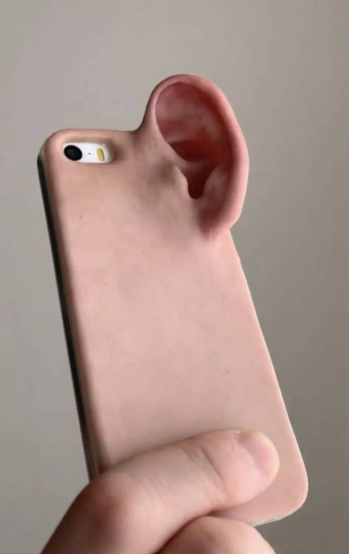 Phone case shaped like a human ear held in a person&#x27;s hand