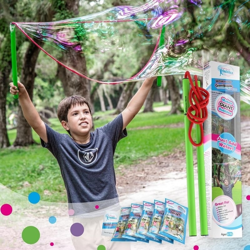 Child plays with a giant bubble wand toy outdoors, with the product packaging shown