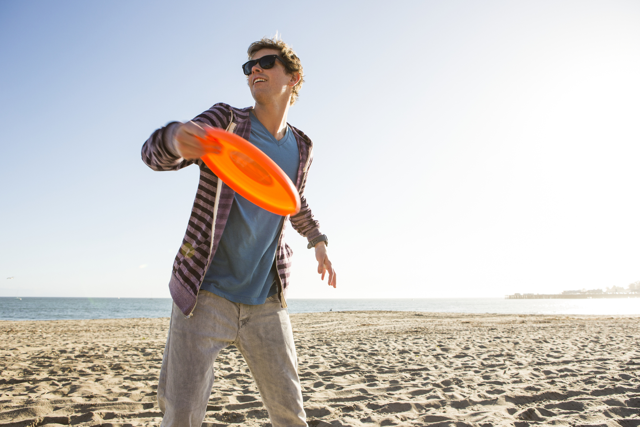 Man throws a frisbee on the beach