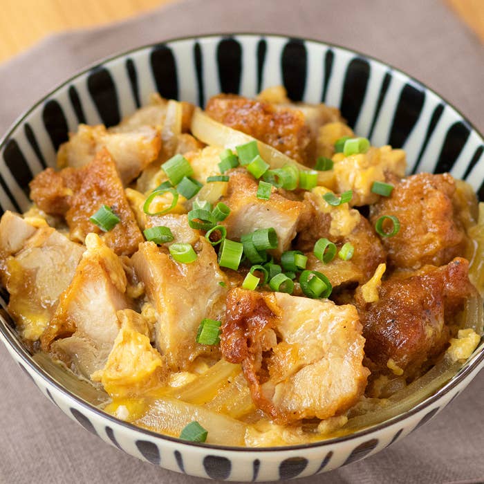鶏肉と玉ねぎがのった親子丼。ネギがトッピングされている。
