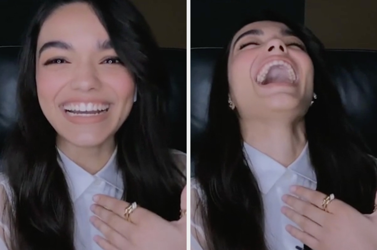 Woman in a white shirt smiling and then laughing with hand on chest