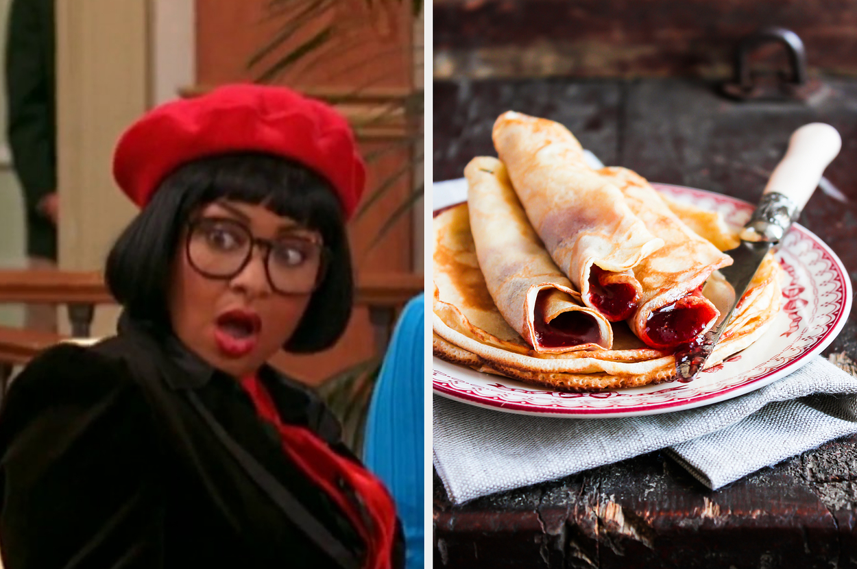 Ugly Betty character with surprised expression in red beret and glasses; a plate of rolled pancakes with filling on a rustic table