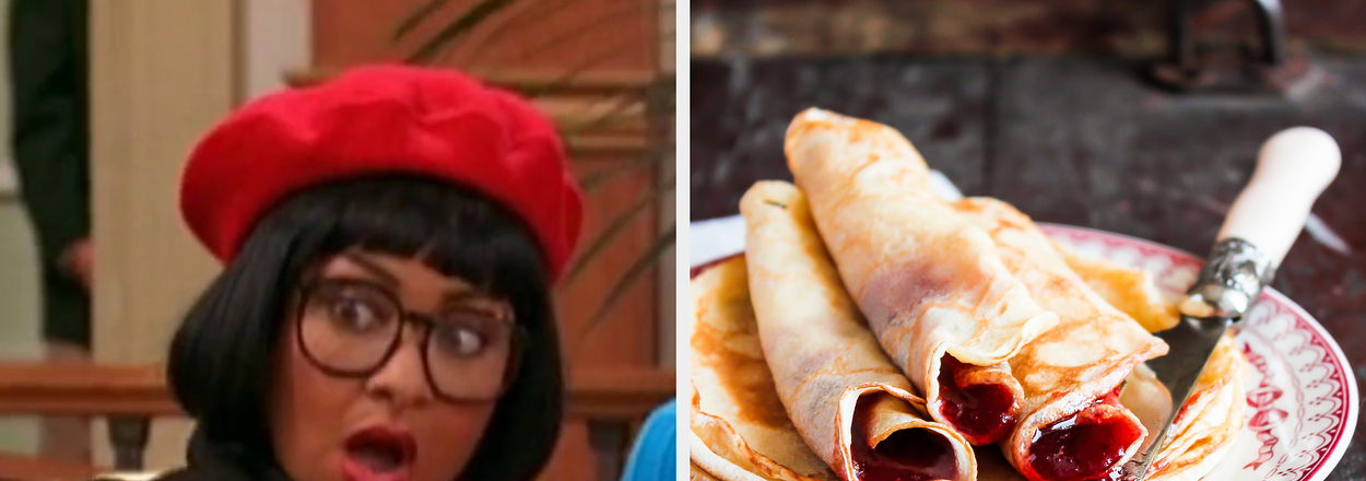 Ugly Betty character with surprised expression in red beret and glasses; a plate of rolled pancakes with filling on a rustic table