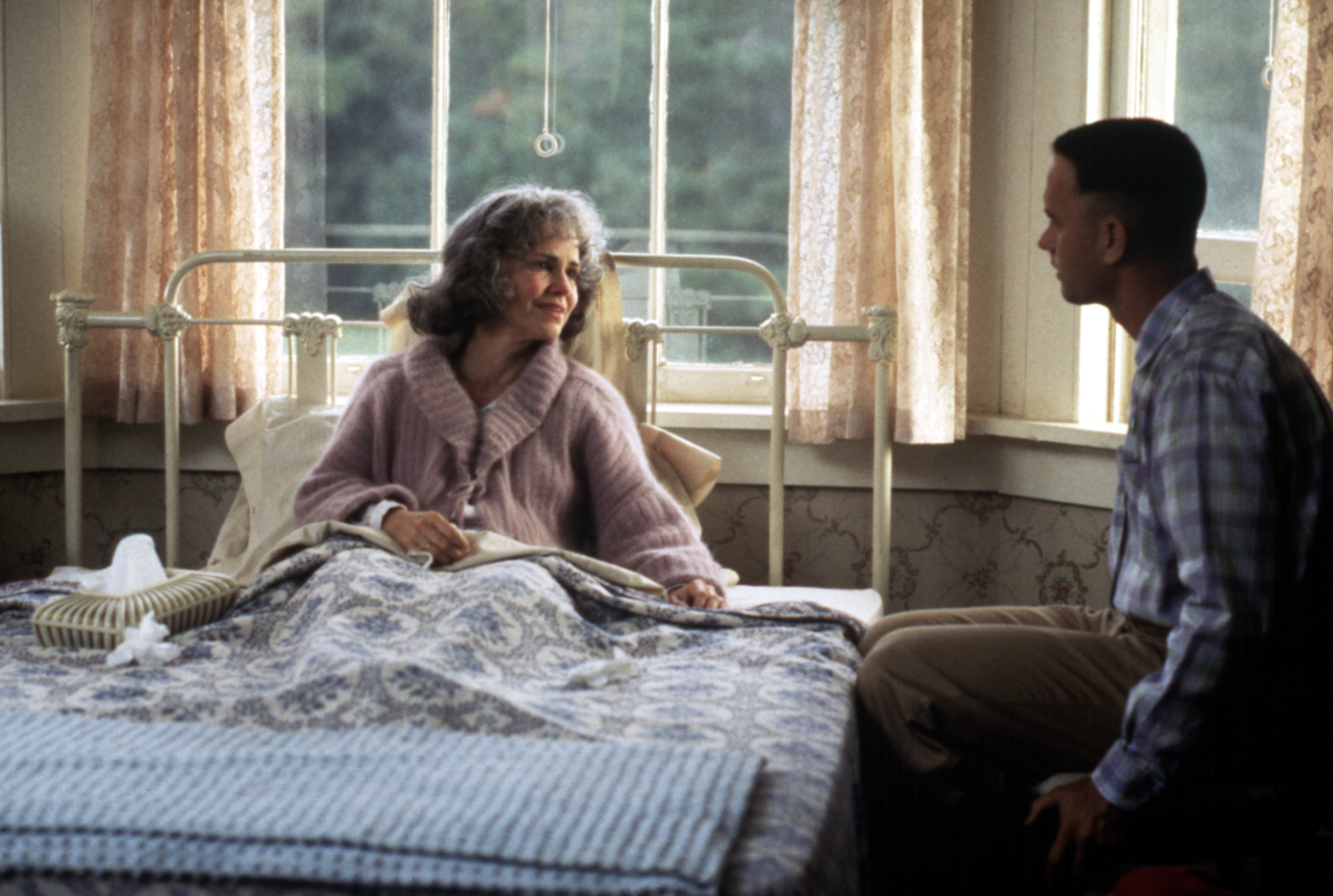 Sally Field on a hospital bed and Tom Hanks on a chair, engaged in conversation