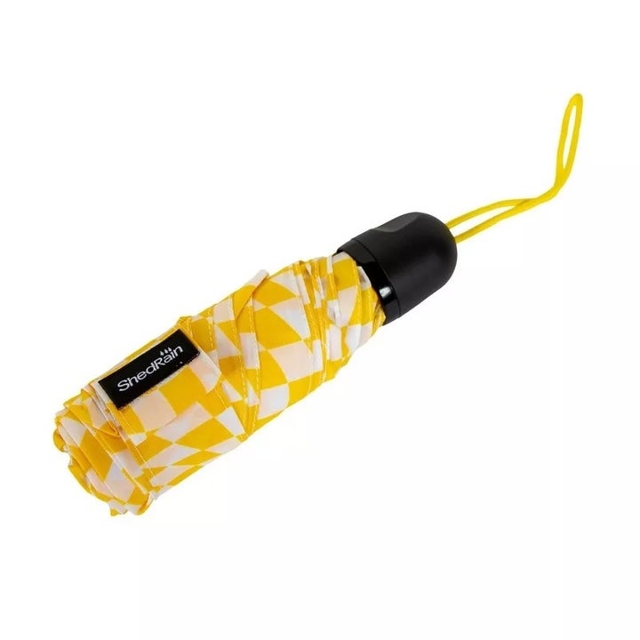Compact umbrella with yellow and white pattern, black handle, and yellow wrist strap