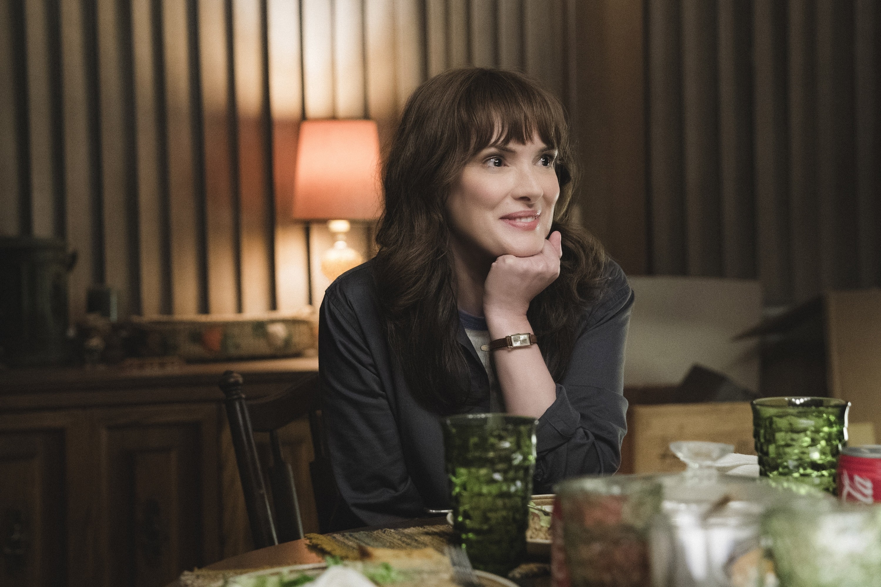 Winona Ryder smiling at a dinner table