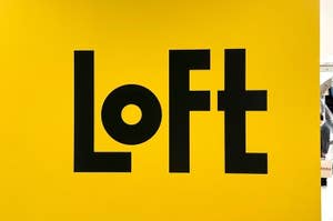黄色い壁に「Loft」という文字があり、背景にはエスカレーターが見える。