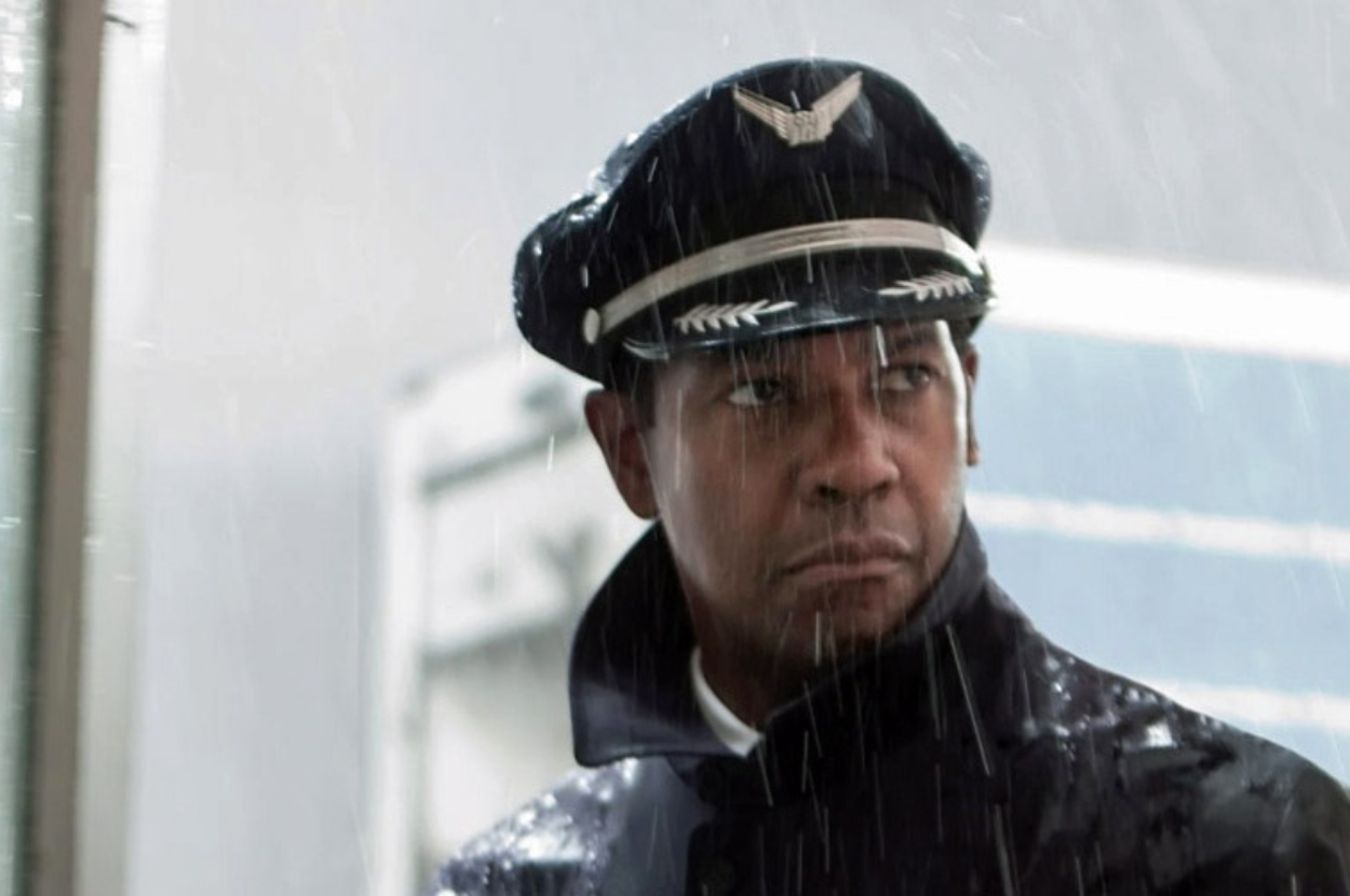 Denzel Washington as a pilot in uniform looking concerned amidst rain