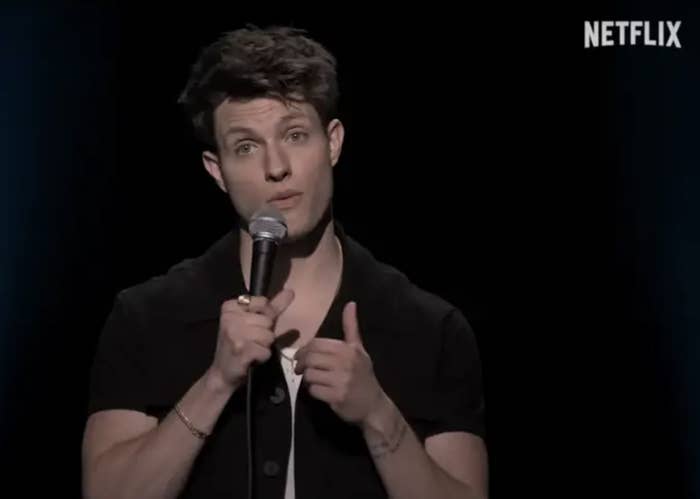 Matt Rife on stage with microphone, pointing forward, against a dark background with Netflix logo